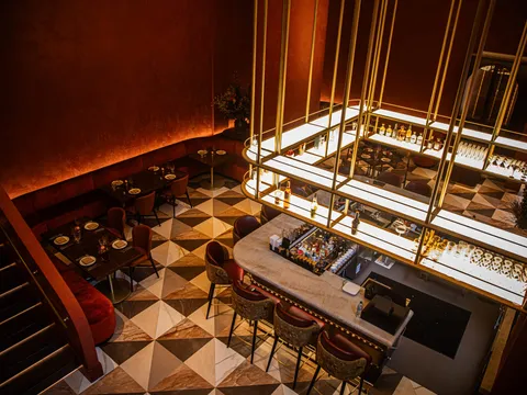 Warmly lit dining room and marble bar at Pataaka in Midtown Atlanta, with deep red walls, gold accents, and a checkered marble floor