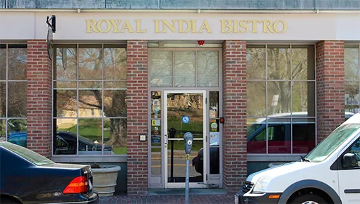 Brick storefront with the illuminated Royal India Bistro sign in Lexington