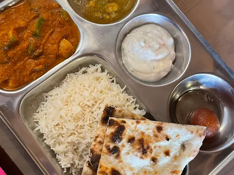 A thali tray with curries, rice, naan, and chutneys from Spice & Tonic.