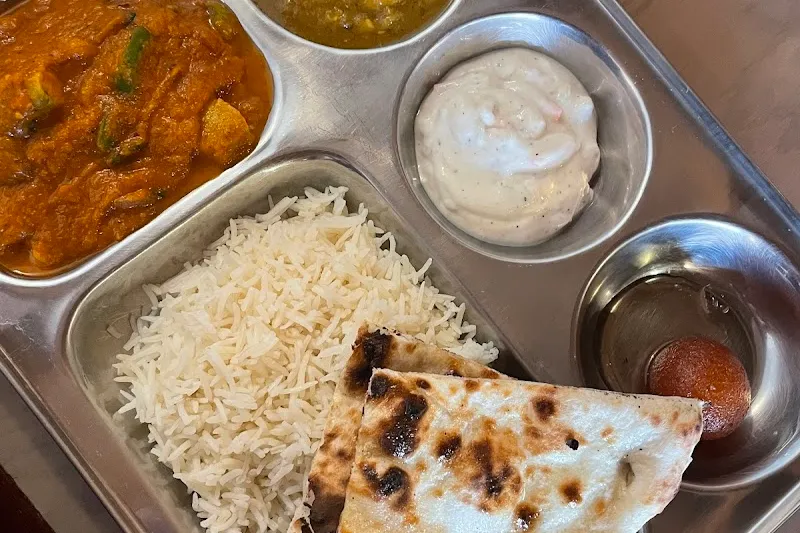 A thali tray with curries, rice, naan, and chutneys from Spice & Tonic.