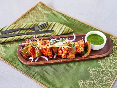 Paneer tikka skewers with green chutney on a wooden platter at Simha Indian Kitchen & Bar in downtown Providence