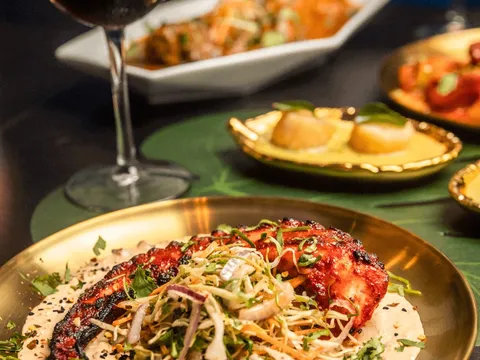 Tandoori octopus plated with slaw on a gold thali, with scallops and sangria, at Moksha Indian Brasserie in Fort Lauderdale