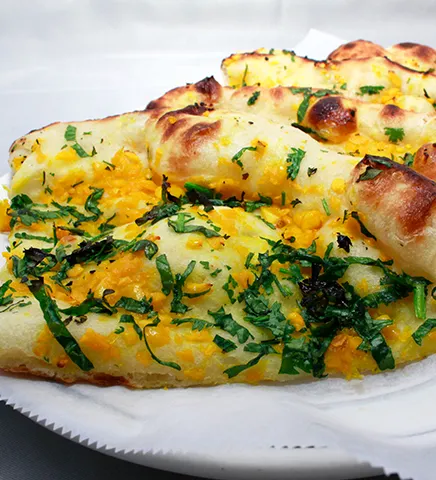 Garlic naan topped with garlic and fresh herbs at Pabla Indian Cuisine