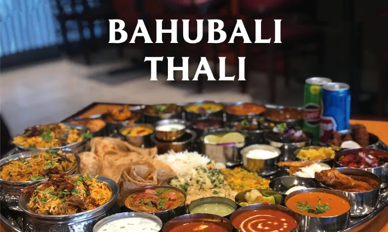 Overhead of Godavari's Bahubali Thali, a large shared platter of biryanis, curries, breads and accompaniments, promotional photo from Godavari in Edison, New Jersey
